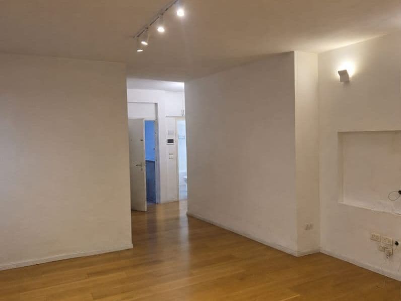 Before: open-plan room with white walls and a wooden floor