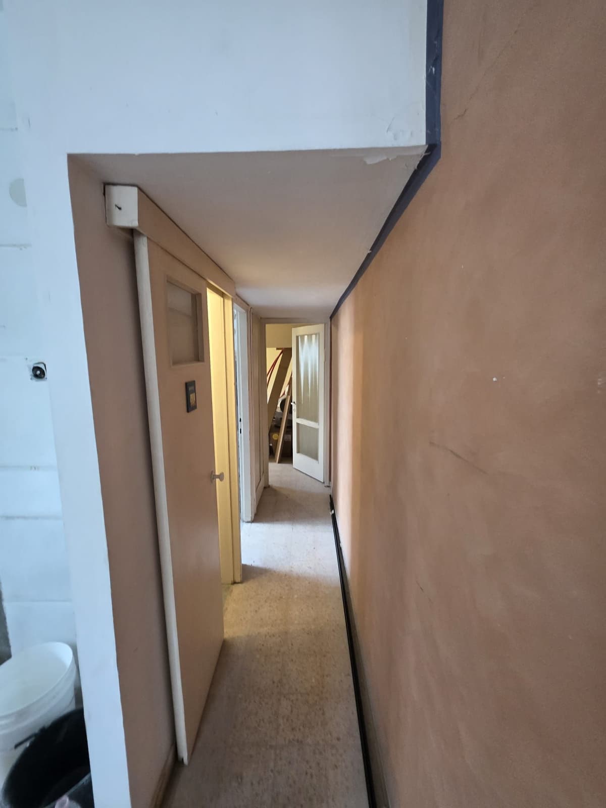 Long hallway with bare brown board walls