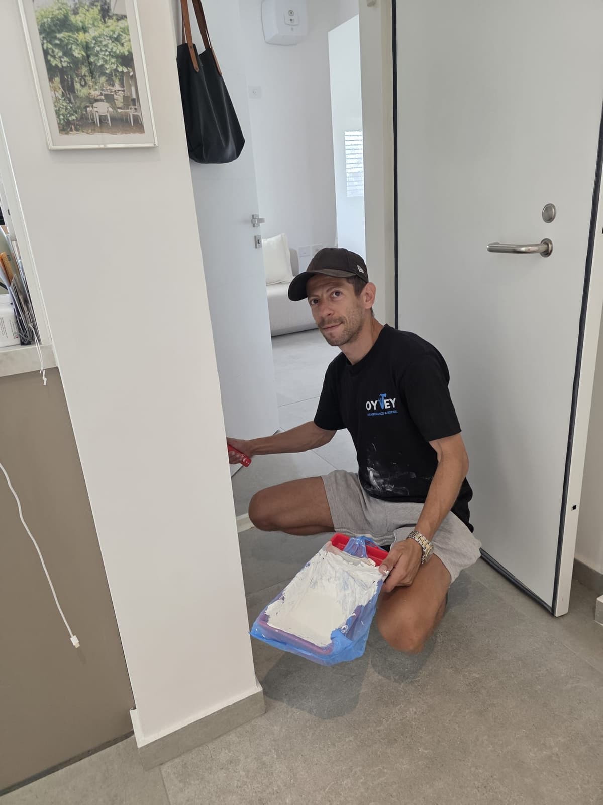 Oy Vey team member painting around a door frame
