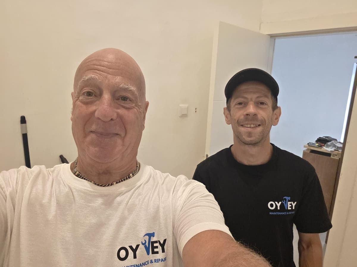 Two members of the Oy Vey team in branded T-shirts at a job