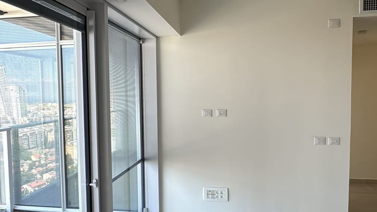Bare living-room wall beside a balcony door