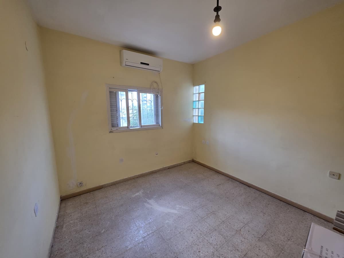Bedroom with yellow walls and an air conditioner above the window